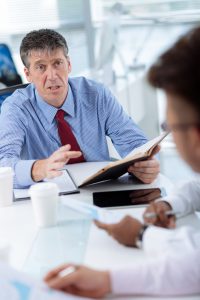 Angry mature businessman talking to his employees